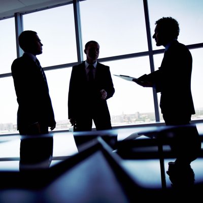 Shady image of a manager discussing business matters with his subordinates